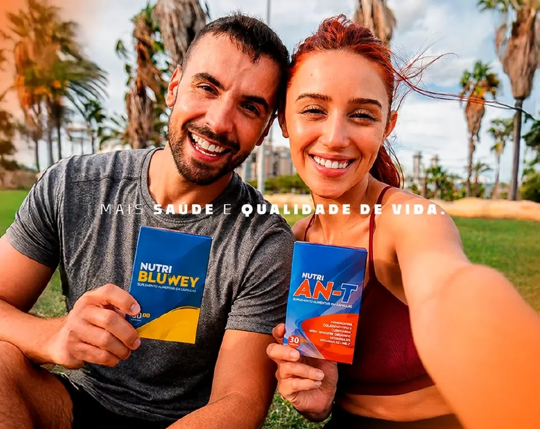 Casal segurando as caixas do suplemento Nutri Ant (Nutri AN-T) e Nutri Bluwey ao ar livre